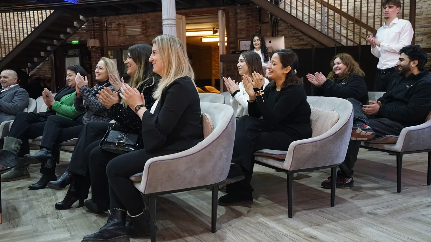 Eine Gruppe applaudiert in Lounge-Sesseln unter der Galerie des XELOR Kesselhaus.
