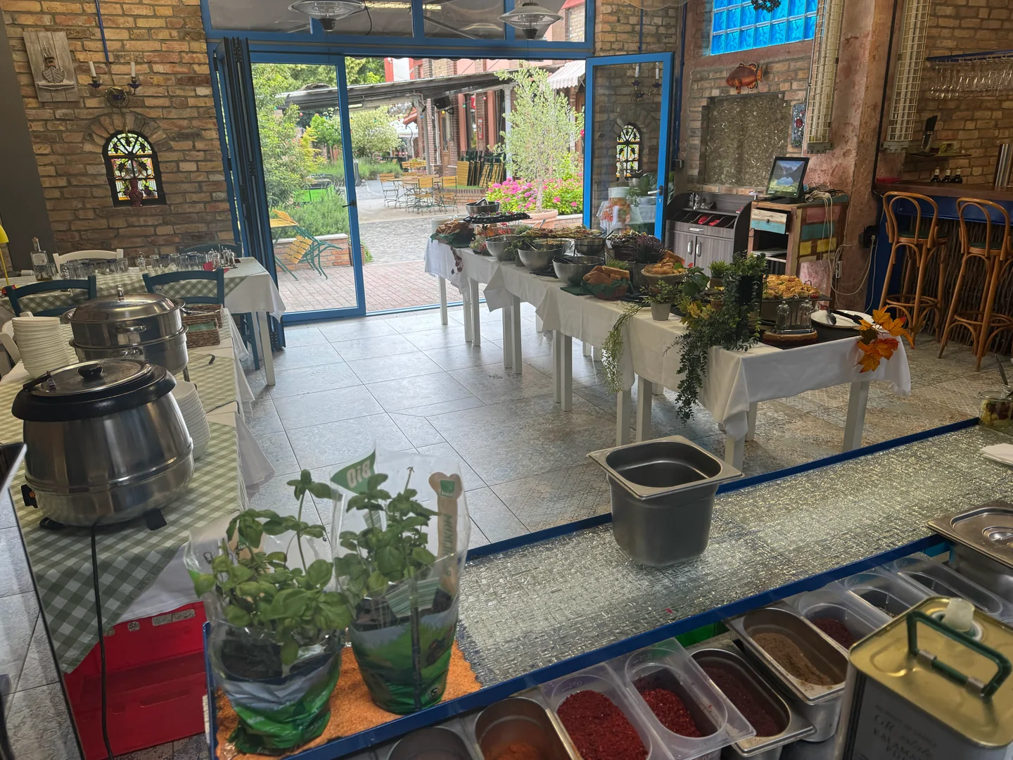 Buffet im Gastronomiebereich des XELOR Kesselhaus mit geöffneten blauen Türen zum Hof.