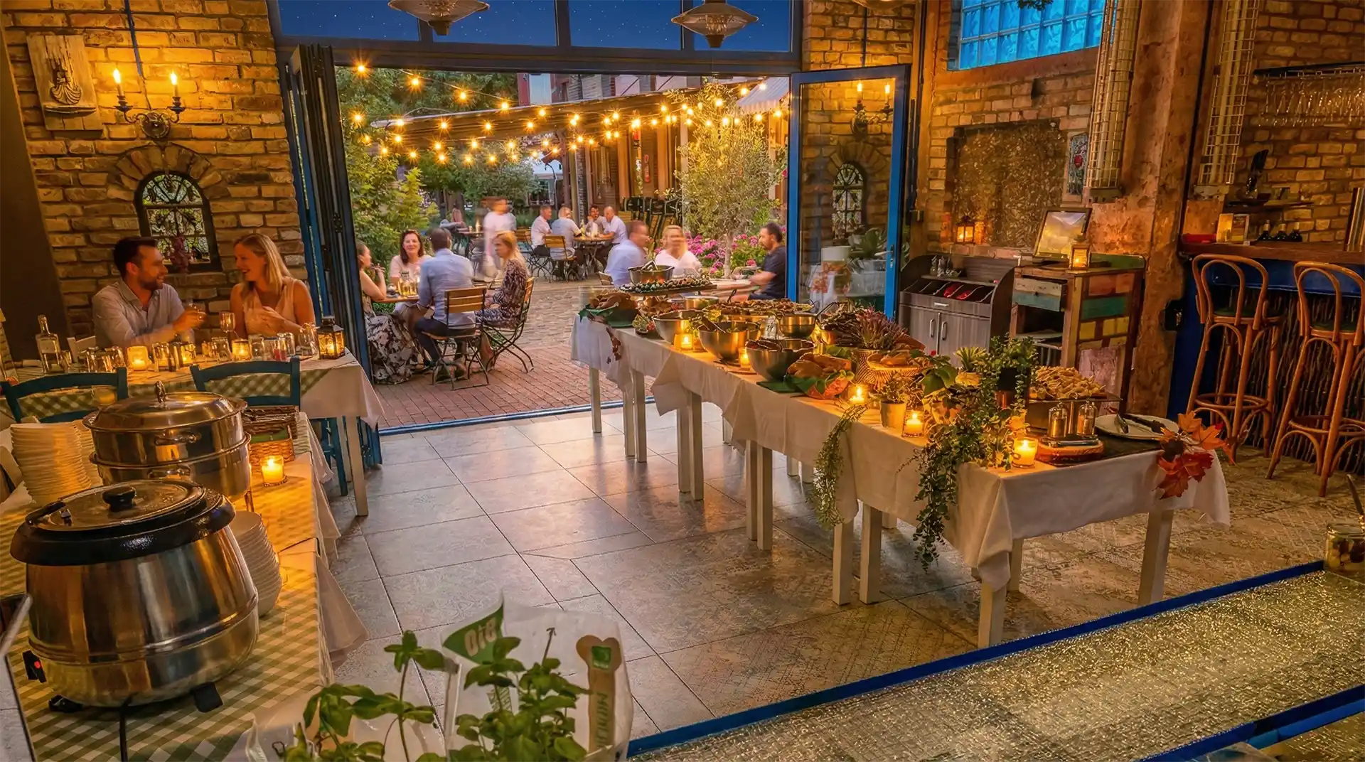 Beleuchteter Innenhof der Sommerparty Location Berlin XELOR Kesselhaus bei Nacht mit Buffet-Aufbau.